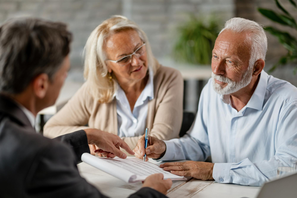 adulto e dois idosos assinando documentos